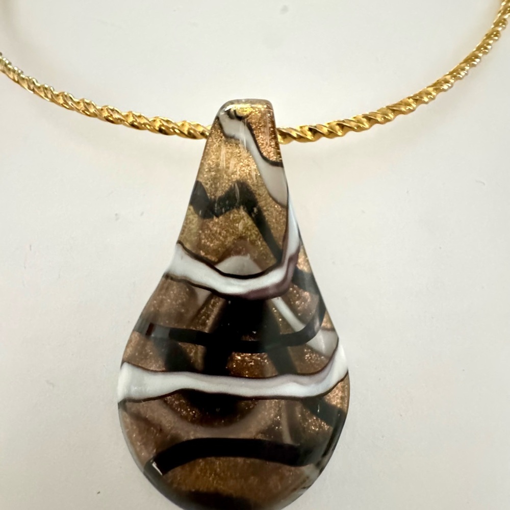 Black, white and glitter bronze slide with gold tone necklace.